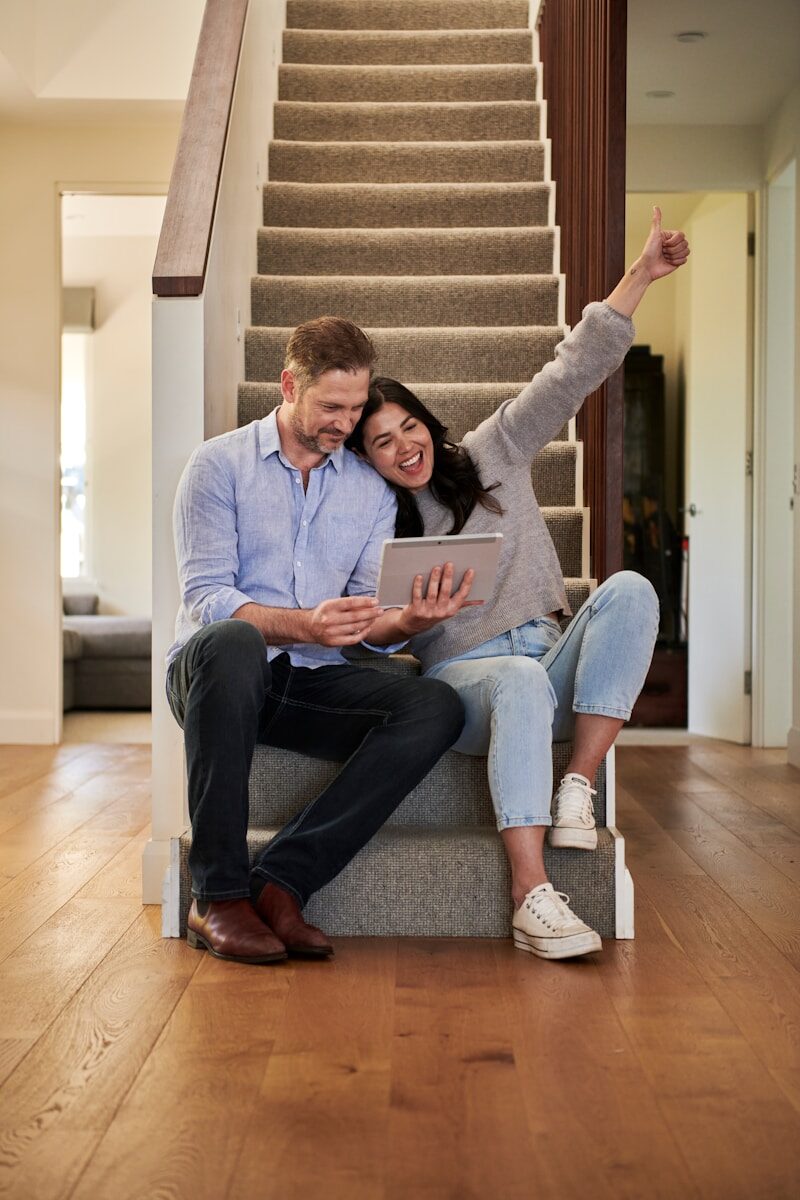 Photo by Docusign woman celebrating besides man looking at tablet